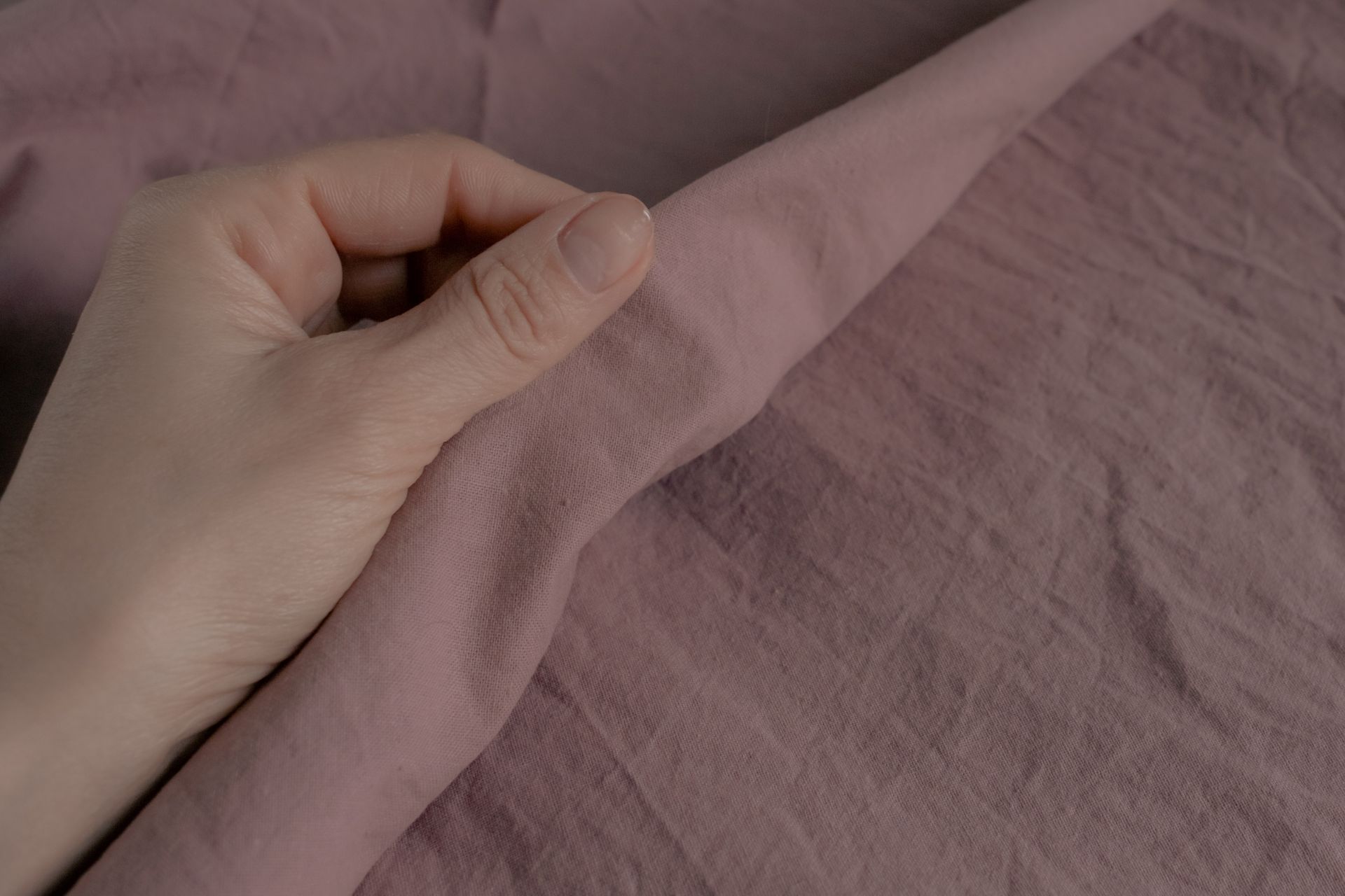 hand-beruehrt-rosa-baumwollstoff-als-symbol-fuer-hautfreundliche-und-nachhaltige-bio-bettwaesche